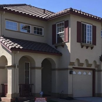 Mediterranean-style two-story home with arched entryway and three-car garage