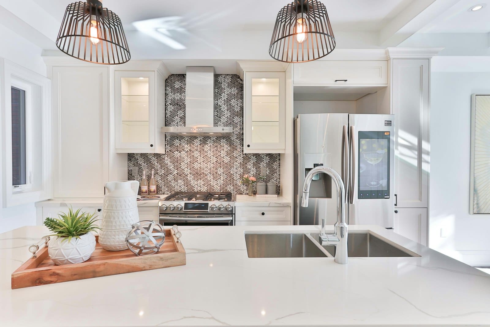 Modern kitchen with white cabinetry, stainless steel appliances, and patterned tile backsplash